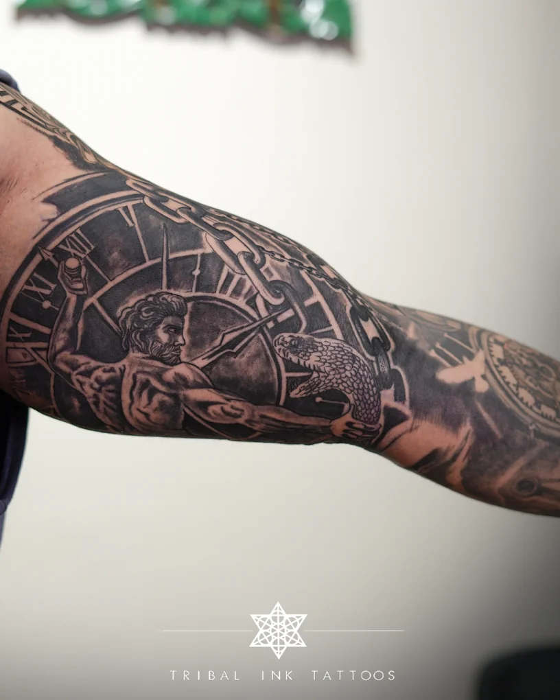 A full sleeve in black and grey showing Poseidon with a trident, a Roman-numeral clock, chains and an eagle.