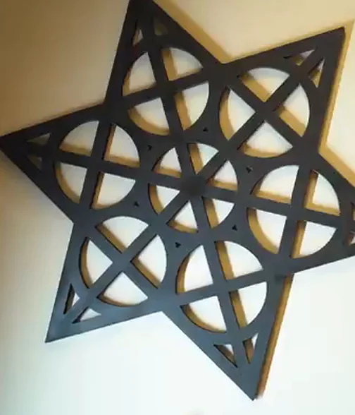 The Tribal Ink geometric star mark, cut in black and mounted on the studio wall.
